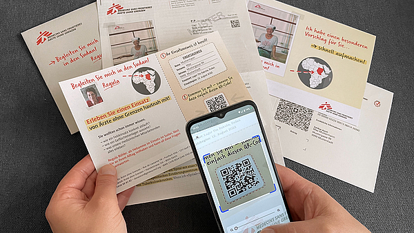 Referenzbild Mailing Kampagne MSF, Hand scannt QR-Code, für Teaser